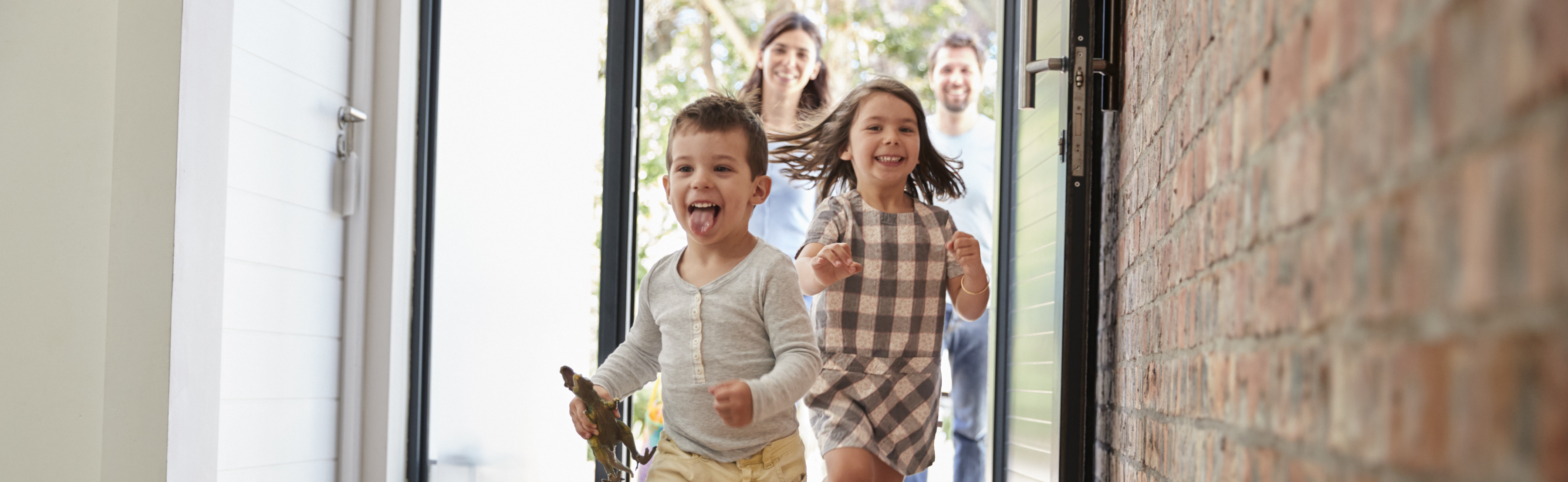 Kids running through front door with parents behind them